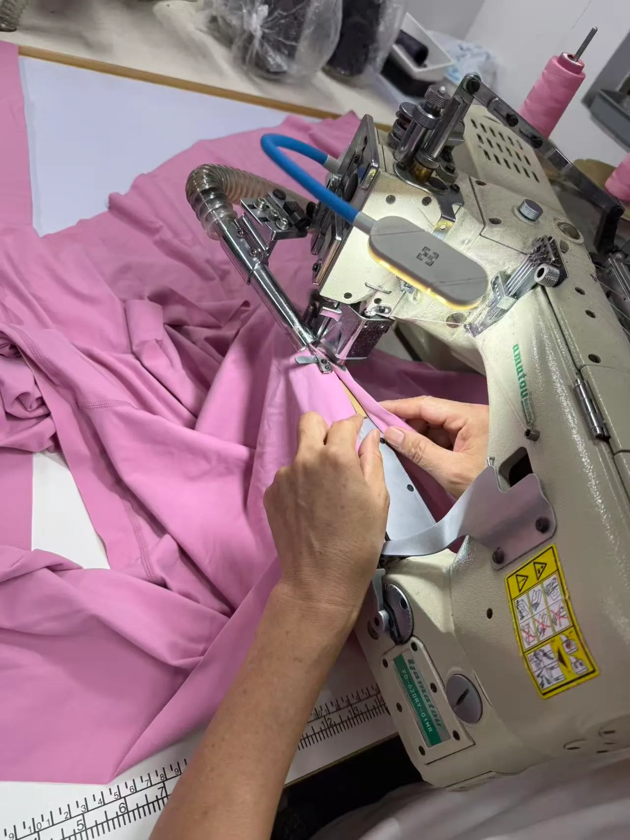 Flatlock seaming on pink stretch knit fabric for activewear at the Humen factory