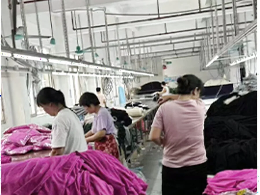 Quality checkers reviewing finished garments at the Humen factory