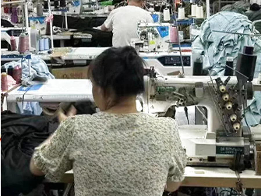 Machine operator sewing a garment on the production line at the Humen factory
